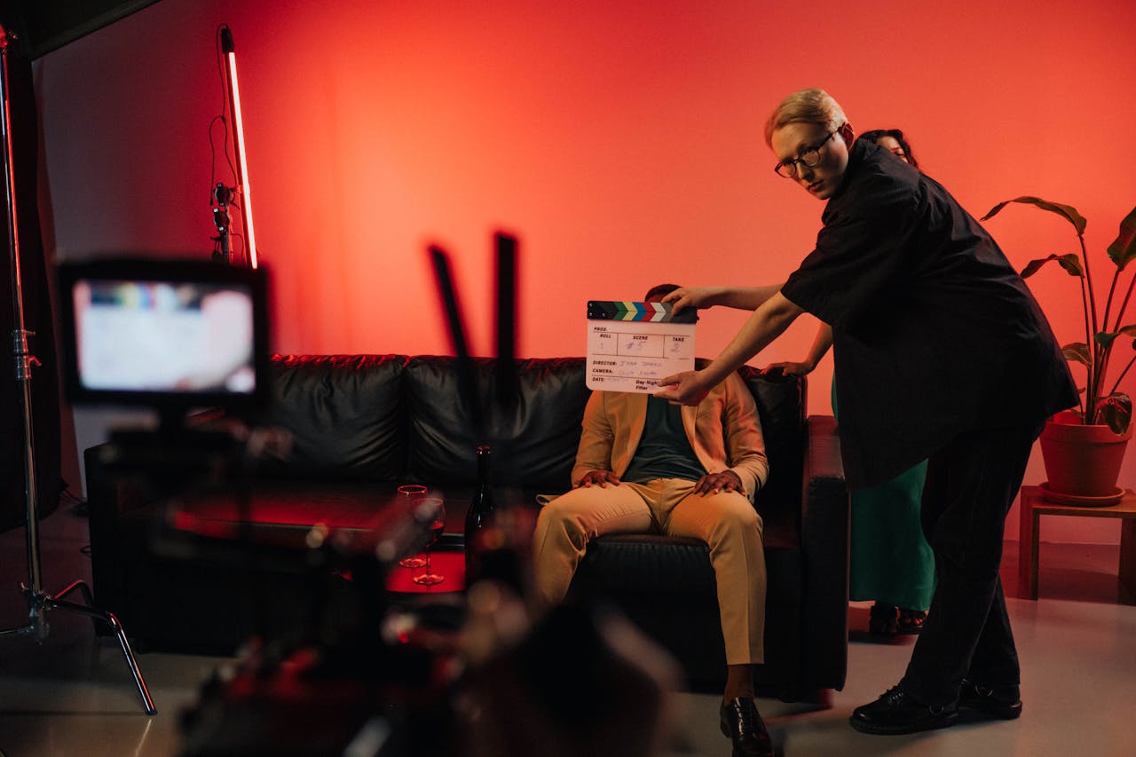 Film production team setting up a scene on an indoor set with dramatic lighting.